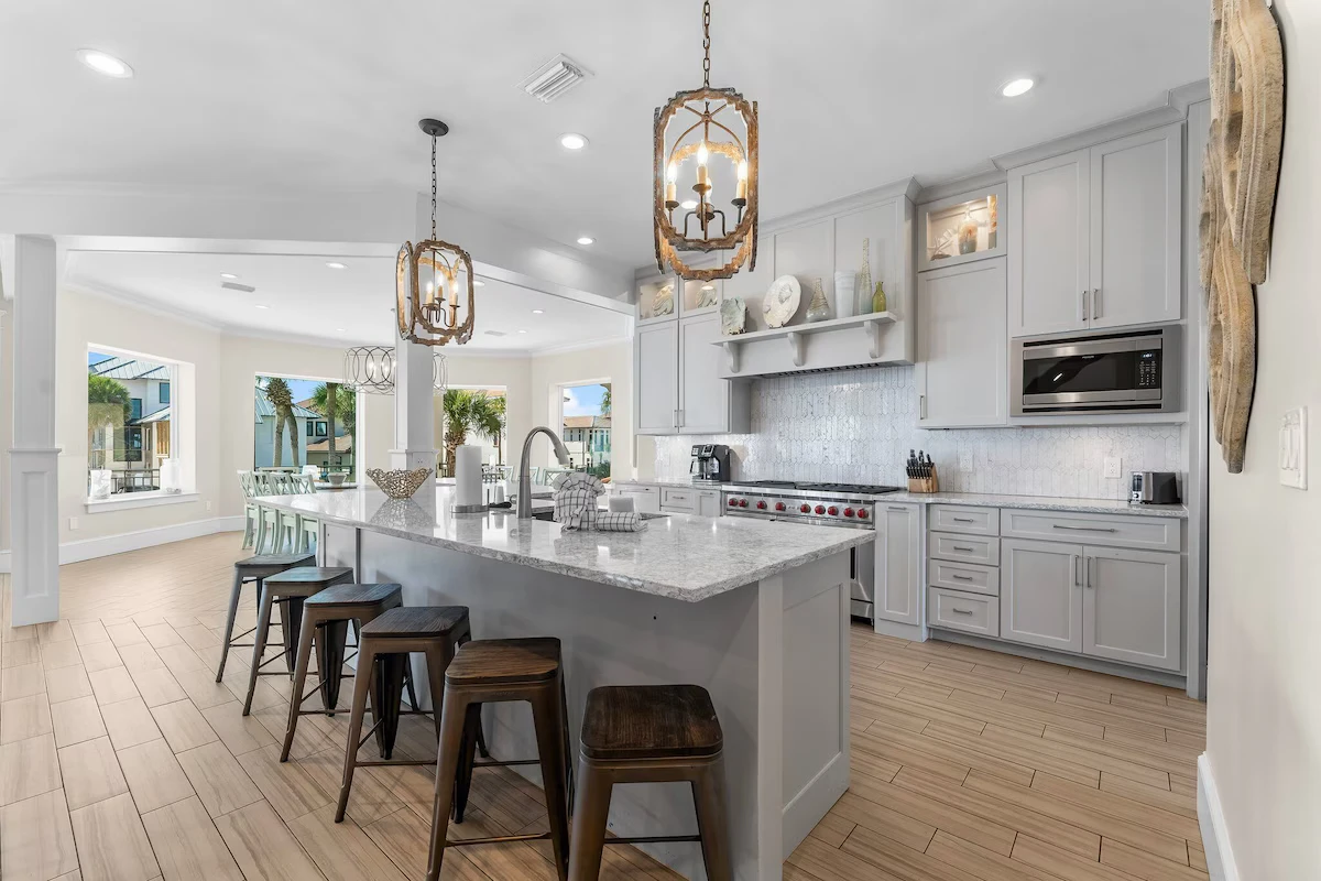Kitchen with a large granite island, bar stools and pendant lights