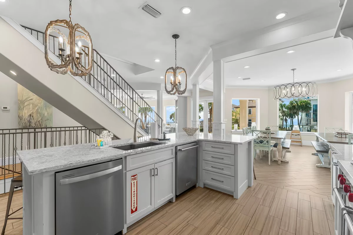 Kitchen sink and dishwashers beside the staircase, with the dining area beyond