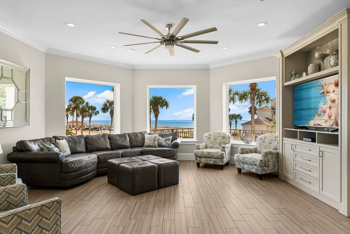 Living room with a leather sectional and windows looking out to the Gulf