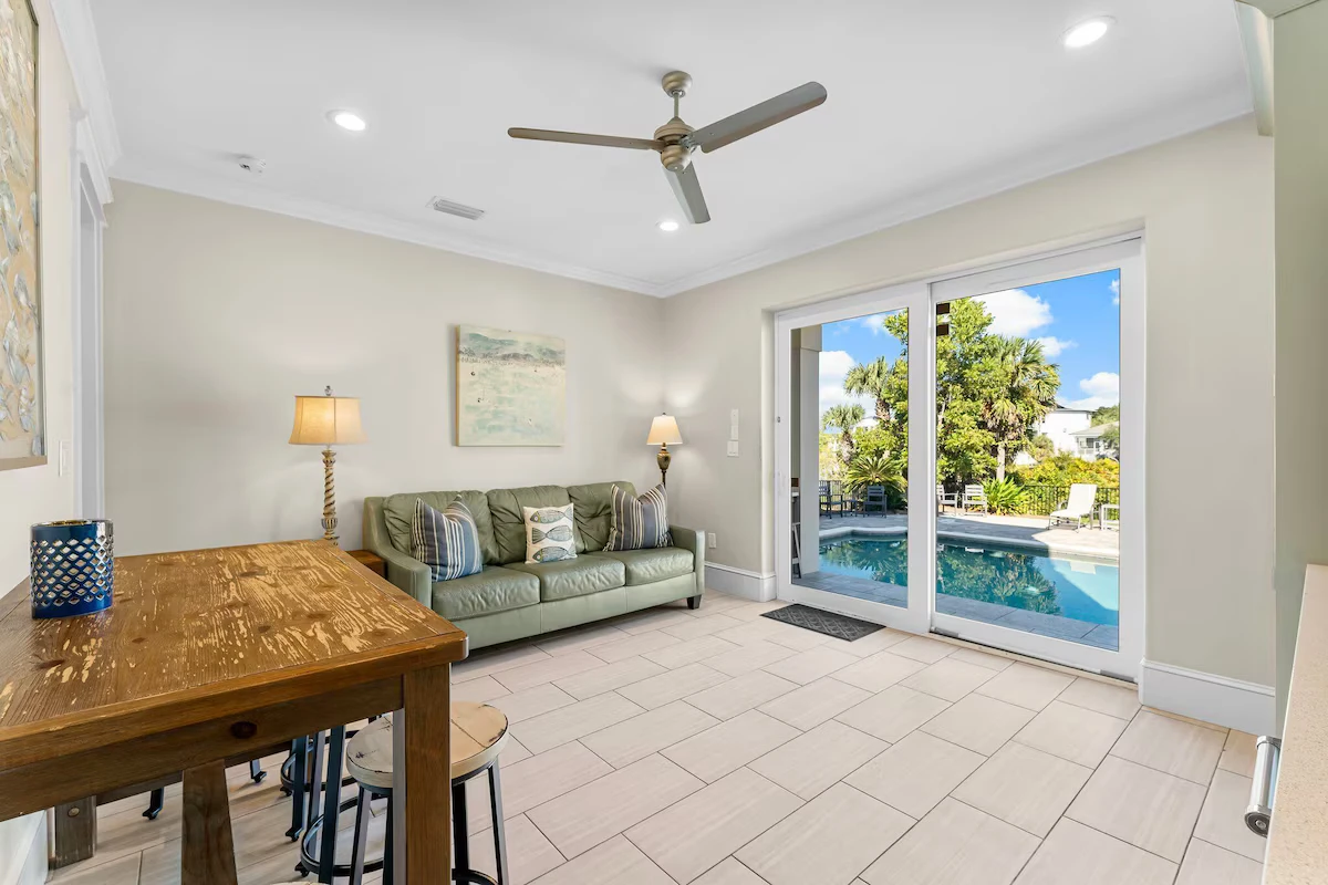 Sitting area with a green sofa and sliding doors to the pool