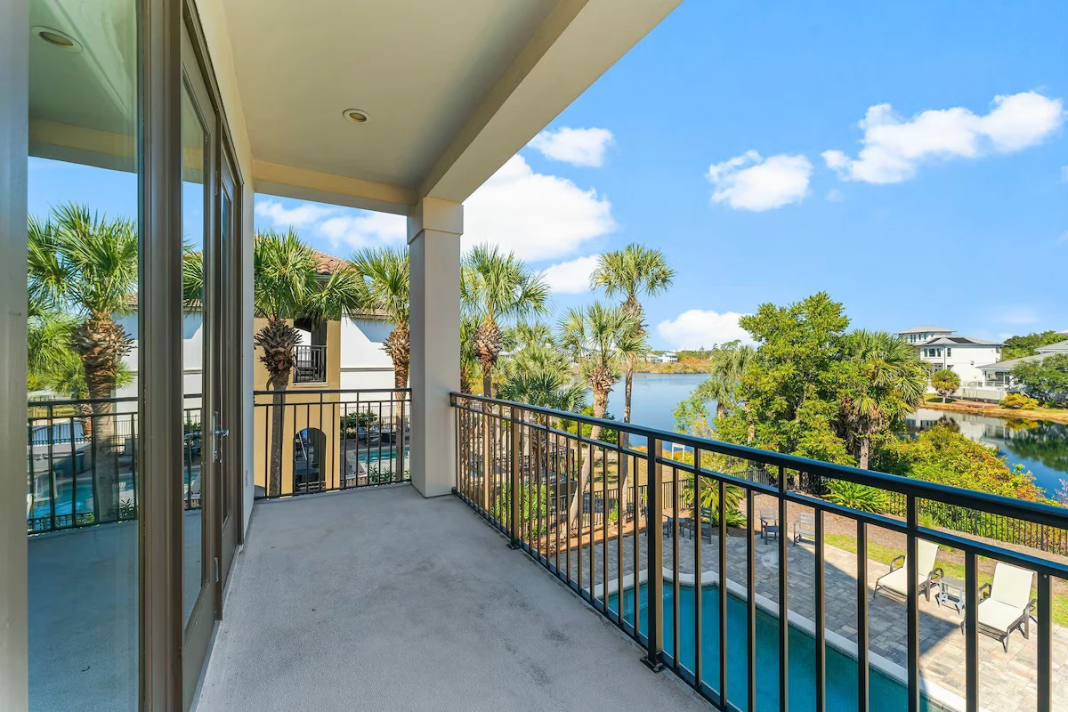 Balcony with a railing overlooking the pool and a lake
